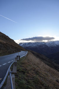 Road leading towards mountains against sky