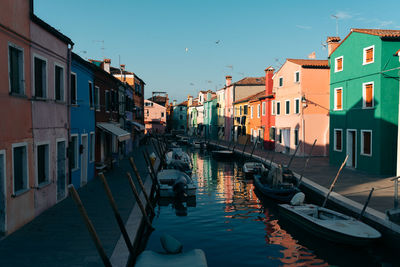 Canal amidst buildings in city against sky