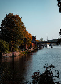 Bridge over river in city against clear sky