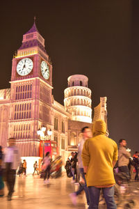 People on illuminated building at night