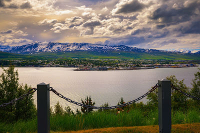 Scenic view of lake by mountain against sky