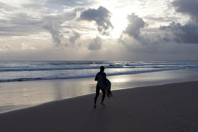 Rear view of woman with horse on beach