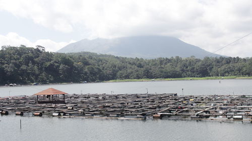 Scenic view of river by mountains against sky