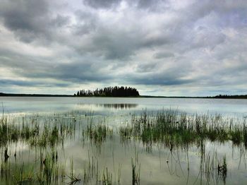 Scenic view of lake against cloudy sky