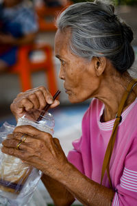 Side view of senior woman having drink