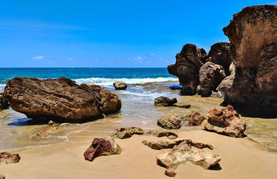 Rocks on beach against sky