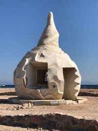 Built structure on beach against clear sky