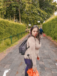 Full length portrait of woman on footpath