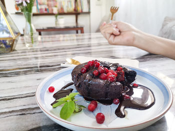 High angle view of hand holding ice cream on table