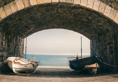 Boat moored on sea shore against sky