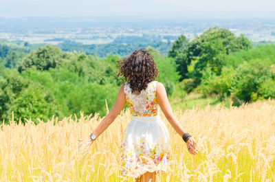 Rear view of woman standing on field