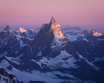 Scenic view of snowcapped mountains against sky during sunset