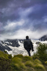 Rear view of man looking at mountain against sky