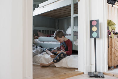 Boy sitting in his bedroom playing computer games in his pyjamas