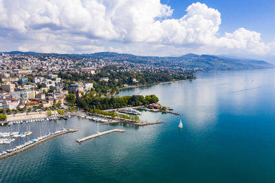 High angle view of city by sea against sky