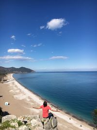 Rear view of man looking at sea against sky