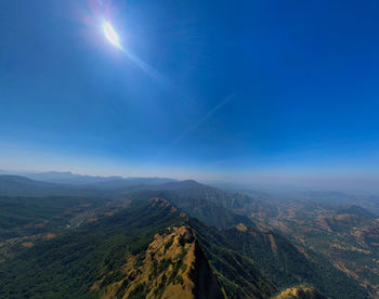 Aerial view of landscape against blue sky