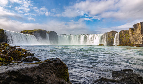 Scenic view of waterfall against sky