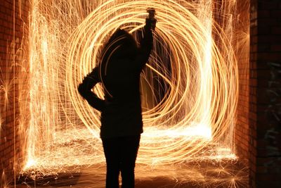Person spinning illuminated wire wool at night