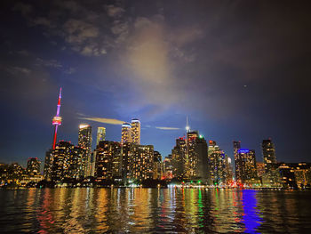 Illuminated buildings in city against sky at night