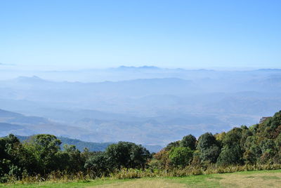 Scenic view of field and mountains against clear sky