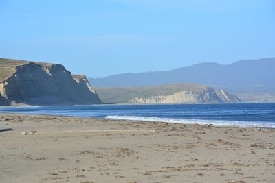 Scenic view of beach against clear blue sky