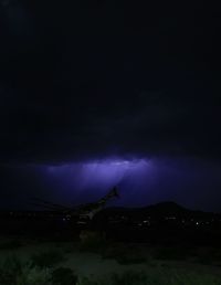Lightning in sky over mountain at night