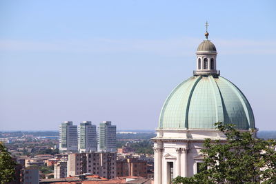 Buildings in city against clear sky