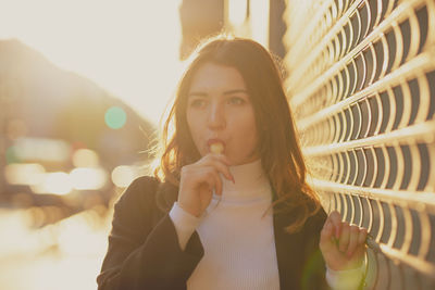 Thoughtful beautiful woman having flavored ice in city