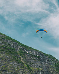 Low angle view of person paragliding against sky