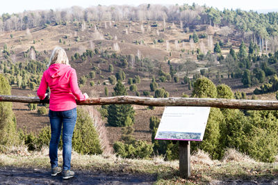 Rear view of woman standing against landscape