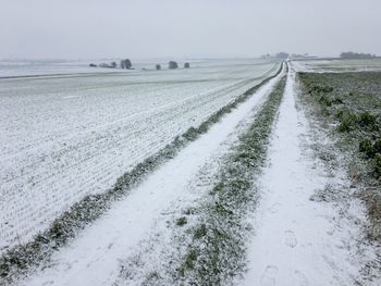 Scenic view of snowy field against sky