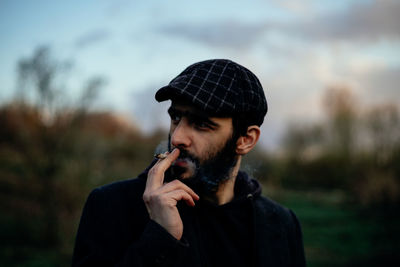 Portrait of young man smoking outdoors