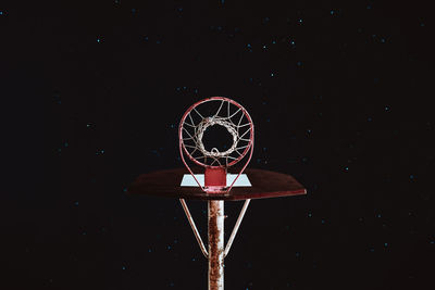 Low angle view of basketball hoop against sky at night