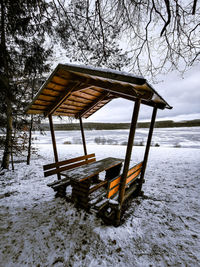 Gazebo on snow covered field against sky