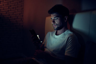 Young man using mobile phone at home