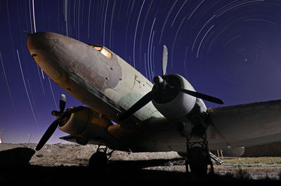 Airplane on runway against clear sky at night