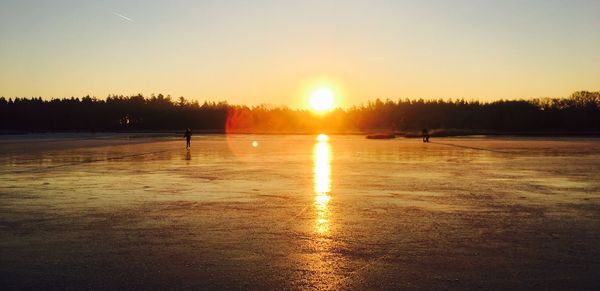 Scenic view of frozen lake against sky during sunset