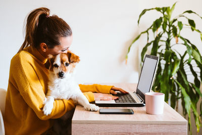 Portrait of woman with dog on mobile phone