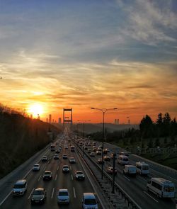 Traffic on road at sunset