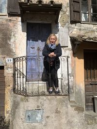 Portrait of woman standing against building