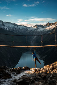 Man walking on snowcapped mountain against sky