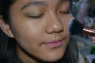 Close-up portrait of young woman with eyes closed