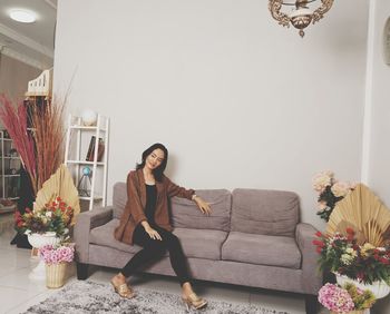 Portrait of young woman sitting on floor at home