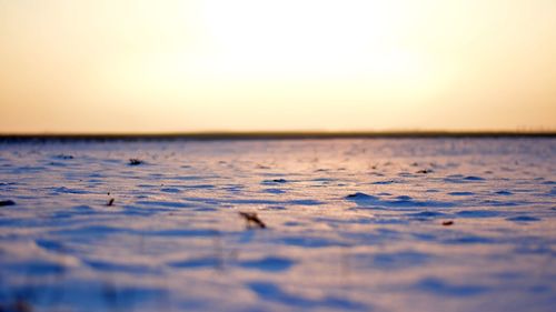 Surface level of snow on beach during sunset