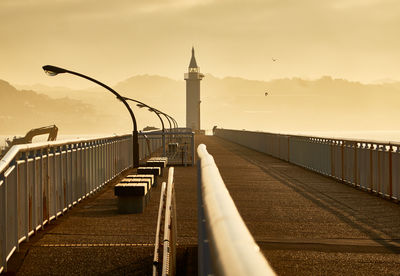 Pier over sea against sky during sunset