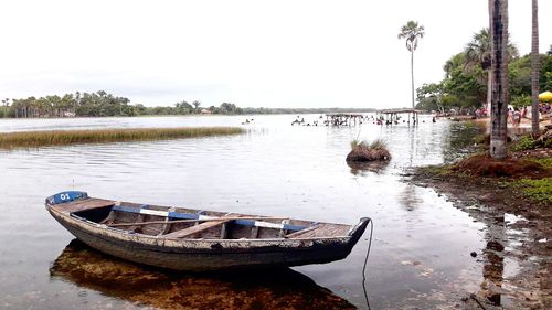 Boat moored in lake against sky