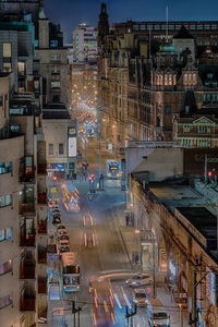 High angle view of illuminated street amidst buildings in city