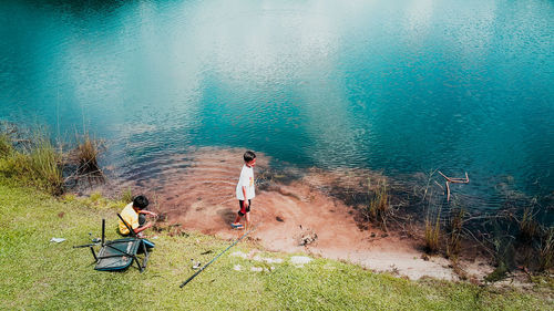 High angle view of people standing by sea against sky