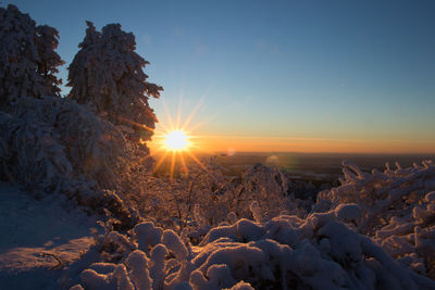 Scenic view of snow covered land against sky during sunset